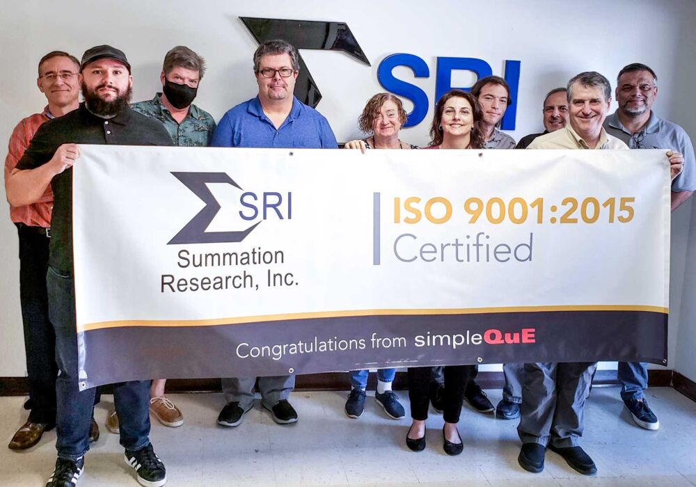 SRI team holding ISO 9001 banner