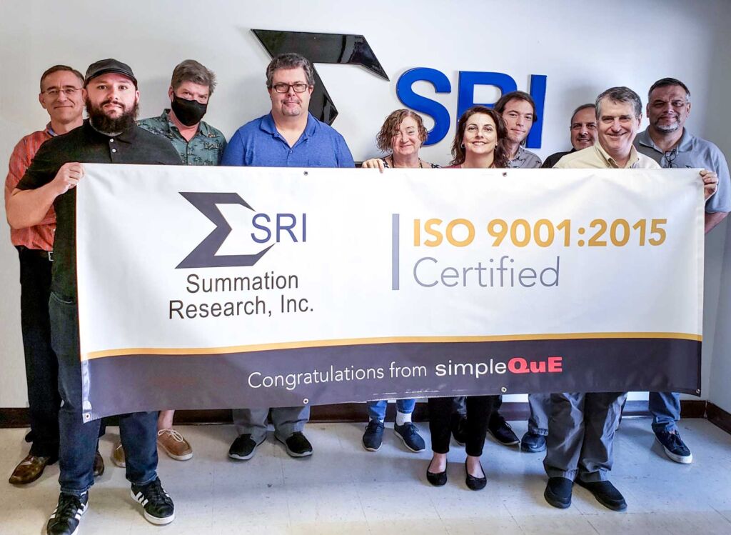 SRI team holding ISO 9001 banner